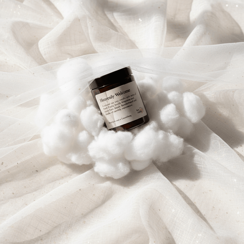 Bernsteinglas-Kerze auf weißem Wolken-Styling aus Watte und Tüll – „Heavenly Welcome", sanft, elegant und einladend