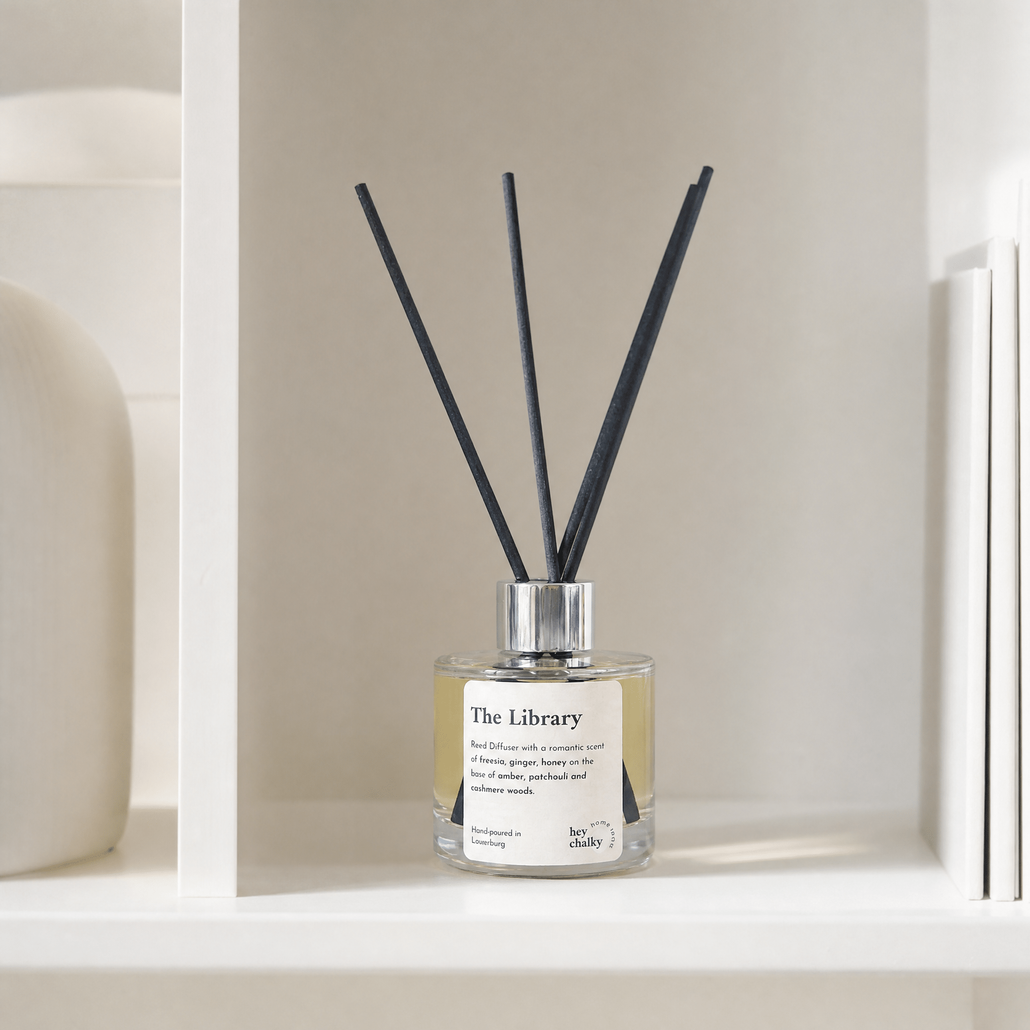 „The Library" auf weißem Bücherregal-Einbauregal – Amber, Sandelholz und Vanille, modernes minimalistisches Wohnzimmer