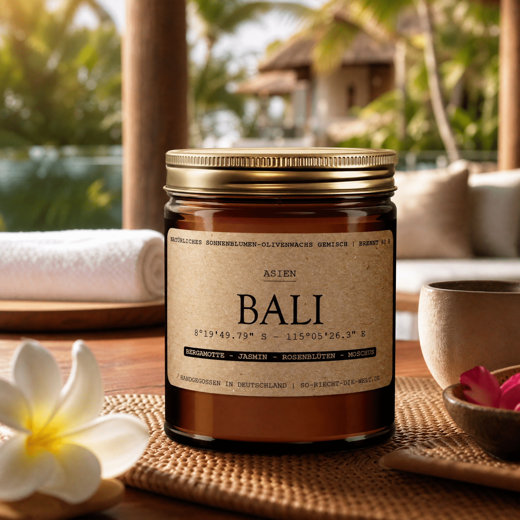 „Bali" auf Teakholztisch mit Frangipani-Blüte, Blick auf Bali-Poolvilla – Bergamotte, Jasmin, Rosenblüten und Moschus