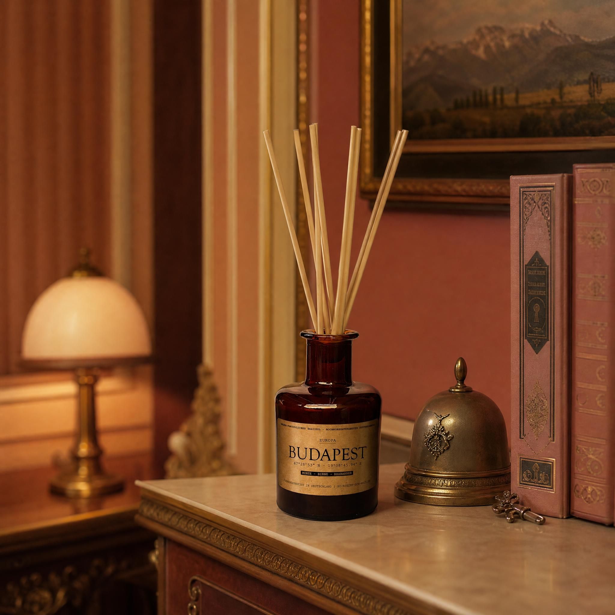 Reed Diffuser „Budapest" auf antikem Regal im Grandhotel-Interieur – Quitte, Birne, Rhabarber, Bernsteinglas