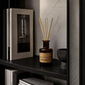 Diffuser „Los Angeles" Carrara-Marmor im Hintergrund, schwarzes Regal mit Architekturbuch und Marmor – Jasmin und Zedernholz